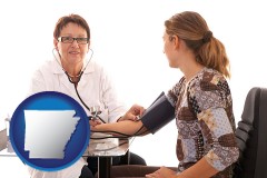 arkansas map icon and a female nurse practitioner checking a patient's blood pressure