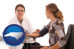 north-carolina map icon and a female nurse practitioner checking a patient's blood pressure