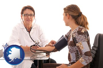 a female nurse practitioner checking a patient's blood pressure - with Alaska icon