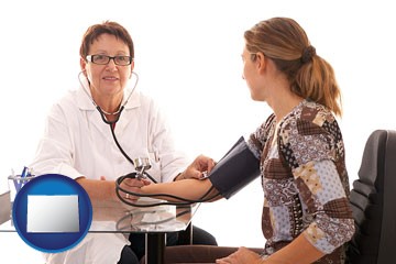 a female nurse practitioner checking a patient's blood pressure - with Colorado icon