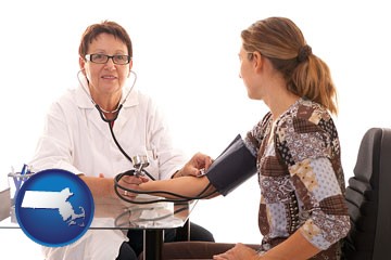 a female nurse practitioner checking a patient's blood pressure - with Massachusetts icon