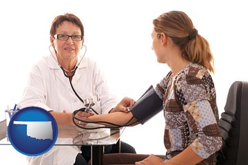 a female nurse practitioner checking a patient's blood pressure - with Oklahoma icon
